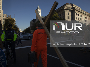 An anti-abortion rights activist carries a cross during the National Women's March in Washington DC, USA, on November 2, 2024. Just days bef...