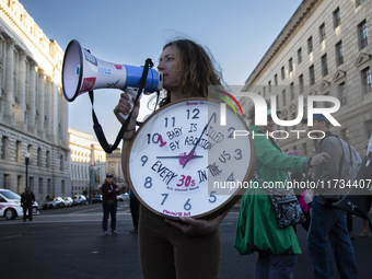 An anti-abortion rights activist holds a watch with some text during the National Women's March in Washington DC, USA, on November 2, 2024....