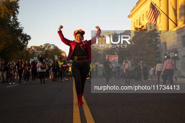 A person poses for photographs during the National Women's March in Washington DC, USA, on November 2, 2024. Just days before the US Electio...