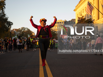 A person poses for photographs during the National Women's March in Washington DC, USA, on November 2, 2024. Just days before the US Electio...