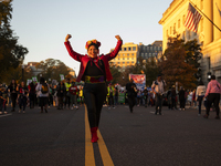 A person poses for photographs during the National Women's March in Washington DC, USA, on November 2, 2024. Just days before the US Electio...