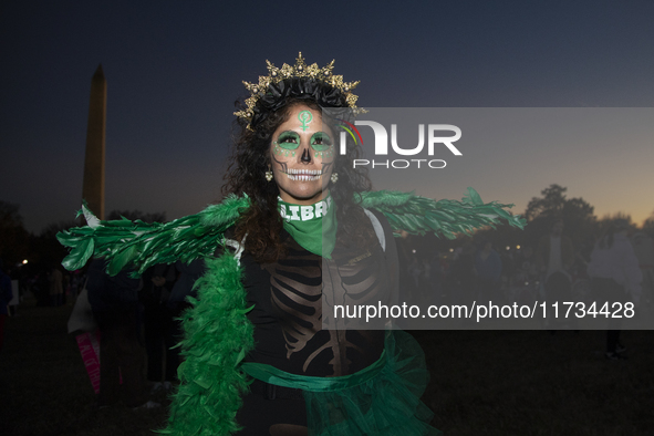 A person poses for photographs during the National Women's March in Washington DC, USA, on November 2, 2024. Just days before the US Electio...