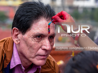 A sister applies tika on her brother's forehead, symbolizing protection and blessings, on the occasion of Bhaitika in Kathmandu, Nepal, on N...