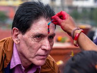 A sister applies tika on her brother's forehead, symbolizing protection and blessings, on the occasion of Bhaitika in Kathmandu, Nepal, on N...