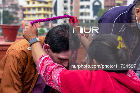 A sister applies tika on her brother's forehead, symbolizing protection and blessings, on the occasion of Bhaitika in Kathmandu, Nepal, on N...