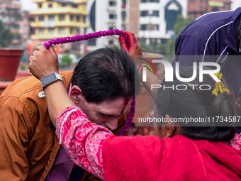 A sister applies tika on her brother's forehead, symbolizing protection and blessings, on the occasion of Bhaitika in Kathmandu, Nepal, on N...