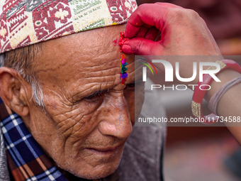 A sister applies tika on her brother's forehead, symbolizing protection and blessings, on the occasion of Bhaitika in Kathmandu, Nepal, on N...