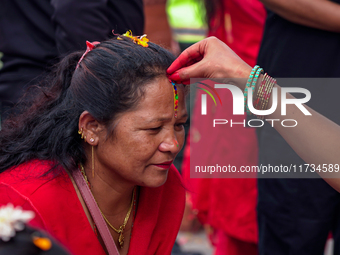 A sister applies tika on her sister's forehead, symbolizing protection and blessings, on the occasion of Bhaitika in Kathmandu, Nepal, on No...