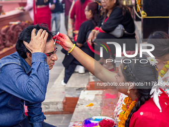 A sister applies tika on her brother's forehead, symbolizing protection and blessings, on the occasion of Bhaitika at Balgopaleshwar Temple...