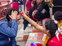 A sister applies tika on her brother's forehead, symbolizing protection and blessings, on the occasion of Bhaitika at Balgopaleshwar Temple...