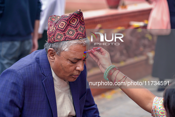 A sister applies tika on her brother's forehead, symbolizing protection and blessings, on the occasion of Bhaitika at Balgopaleshwar Temple...