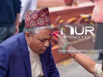 A sister applies tika on her brother's forehead, symbolizing protection and blessings, on the occasion of Bhaitika at Balgopaleshwar Temple...