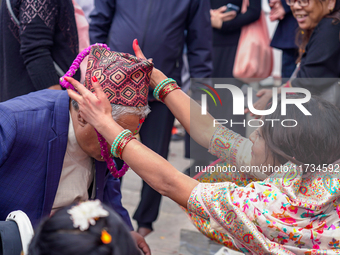 A sister applies tika on her brother's forehead, symbolizing protection and blessings, on the occasion of Bhaitika at Balgopaleshwar Temple...