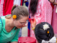 A sister applies tika on a tourist's forehead, symbolizing protection and blessings, on the occasion of Bhaitika at Balgopaleshwar Temple in...