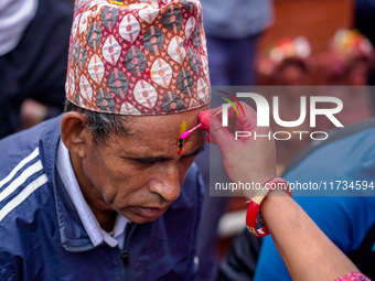 A sister applies tika on her brother's forehead, symbolizing protection and blessings, on the occasion of Bhaitika in Kathmandu, Nepal, on N...