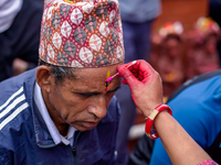 A sister applies tika on her brother's forehead, symbolizing protection and blessings, on the occasion of Bhaitika in Kathmandu, Nepal, on N...