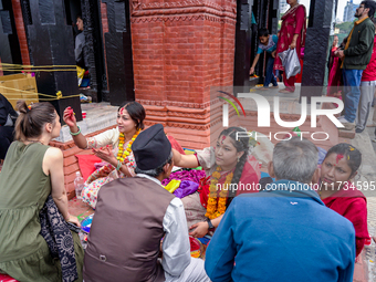 A sister applies tika on her brother's forehead, symbolizing protection and blessings, on the occasion of Bhaitika in Kathmandu, Nepal, on N...