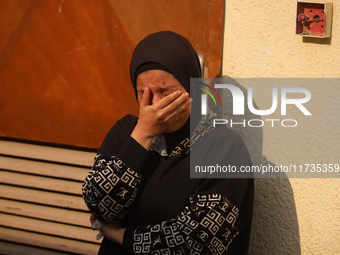 Mourners weep near the bodies of Palestinians killed in an Israeli airstrike amid the conflict between Israel and Hamas in Deir al-Balah, ce...