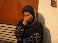 Mourners weep near the bodies of Palestinians killed in an Israeli airstrike amid the conflict between Israel and Hamas in Deir al-Balah, ce...