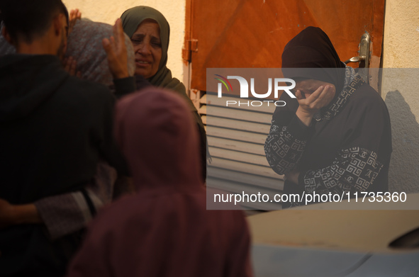 Mourners weep near the bodies of Palestinians killed in an Israeli airstrike amid the conflict between Israel and Hamas in Deir al-Balah, ce...