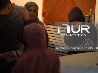 Mourners weep near the bodies of Palestinians killed in an Israeli airstrike amid the conflict between Israel and Hamas in Deir al-Balah, ce...