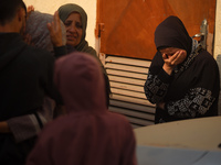 Mourners weep near the bodies of Palestinians killed in an Israeli airstrike amid the conflict between Israel and Hamas in Deir al-Balah, ce...