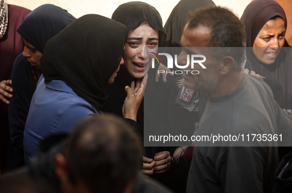 Mourners weep near the bodies of Palestinians killed in an Israeli airstrike amid the conflict between Israel and Hamas in Deir al-Balah, ce...