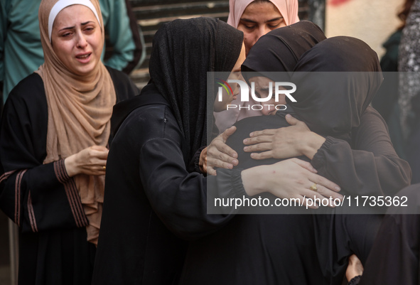 Mourners weep near the bodies of Palestinians killed in an Israeli airstrike amid the conflict between Israel and Hamas in Deir al-Balah, ce...