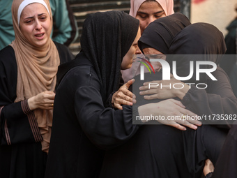 Mourners weep near the bodies of Palestinians killed in an Israeli airstrike amid the conflict between Israel and Hamas in Deir al-Balah, ce...