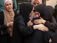 Mourners weep near the bodies of Palestinians killed in an Israeli airstrike amid the conflict between Israel and Hamas in Deir al-Balah, ce...