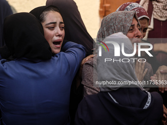 Mourners weep near the bodies of Palestinians killed in an Israeli airstrike amid the conflict between Israel and Hamas in Deir al-Balah, ce...