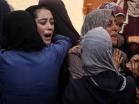 Mourners weep near the bodies of Palestinians killed in an Israeli airstrike amid the conflict between Israel and Hamas in Deir al-Balah, ce...