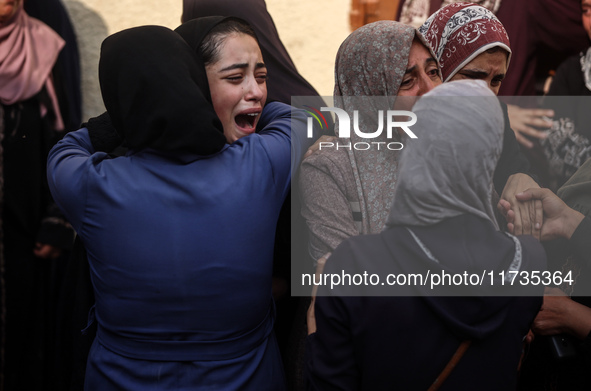 Mourners weep near the bodies of Palestinians killed in an Israeli airstrike amid the conflict between Israel and Hamas in Deir al-Balah, ce...