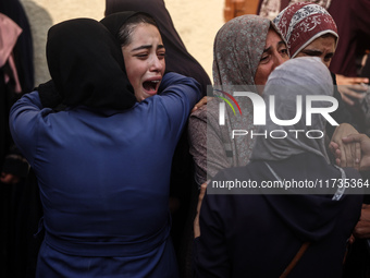 Mourners weep near the bodies of Palestinians killed in an Israeli airstrike amid the conflict between Israel and Hamas in Deir al-Balah, ce...