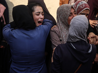 Mourners weep near the bodies of Palestinians killed in an Israeli airstrike amid the conflict between Israel and Hamas in Deir al-Balah, ce...