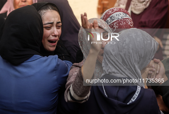 Mourners weep near the bodies of Palestinians killed in an Israeli airstrike amid the conflict between Israel and Hamas in Deir al-Balah, ce...