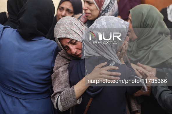 Mourners weep near the bodies of Palestinians killed in an Israeli airstrike amid the conflict between Israel and Hamas in Deir al-Balah, ce...