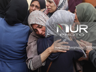 Mourners weep near the bodies of Palestinians killed in an Israeli airstrike amid the conflict between Israel and Hamas in Deir al-Balah, ce...