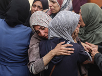 Mourners weep near the bodies of Palestinians killed in an Israeli airstrike amid the conflict between Israel and Hamas in Deir al-Balah, ce...