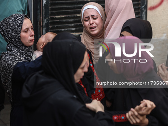 Mourners weep near the bodies of Palestinians killed in an Israeli airstrike amid the conflict between Israel and Hamas in Deir al-Balah, ce...