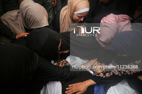 Mourners gather around the bodies of Palestinians killed in an Israeli strike amid the Israel-Hamas conflict in Deir Al-Balah, in the centra...