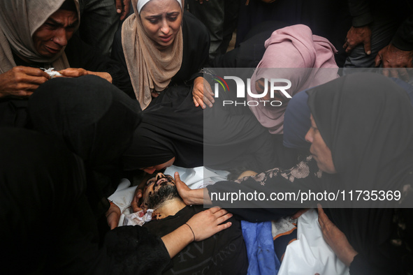 Mourners gather around the bodies of Palestinians killed in an Israeli strike amid the Israel-Hamas conflict in Deir Al-Balah, in the centra...