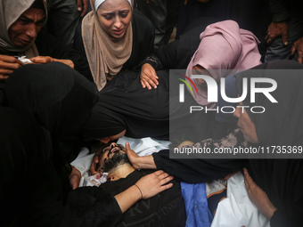 Mourners gather around the bodies of Palestinians killed in an Israeli strike amid the Israel-Hamas conflict in Deir Al-Balah, in the centra...