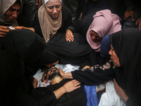 Mourners gather around the bodies of Palestinians killed in an Israeli strike amid the Israel-Hamas conflict in Deir Al-Balah, in the centra...