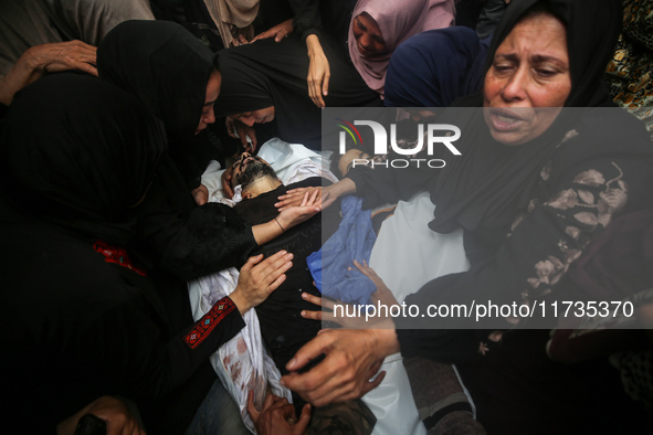 Mourners gather around the bodies of Palestinians killed in an Israeli strike amid the Israel-Hamas conflict in Deir Al-Balah, in the centra...