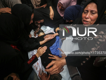 Mourners gather around the bodies of Palestinians killed in an Israeli strike amid the Israel-Hamas conflict in Deir Al-Balah, in the centra...