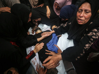 Mourners gather around the bodies of Palestinians killed in an Israeli strike amid the Israel-Hamas conflict in Deir Al-Balah, in the centra...