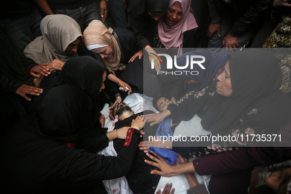 Mourners gather around the bodies of Palestinians killed in an Israeli strike amid the Israel-Hamas conflict in Deir Al-Balah, in the centra...