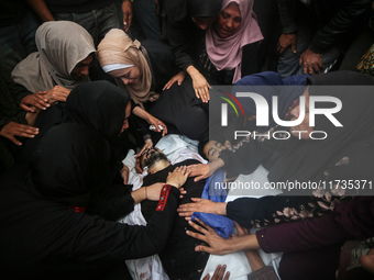 Mourners gather around the bodies of Palestinians killed in an Israeli strike amid the Israel-Hamas conflict in Deir Al-Balah, in the centra...