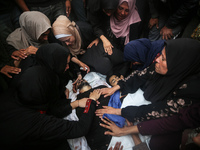 Mourners gather around the bodies of Palestinians killed in an Israeli strike amid the Israel-Hamas conflict in Deir Al-Balah, in the centra...